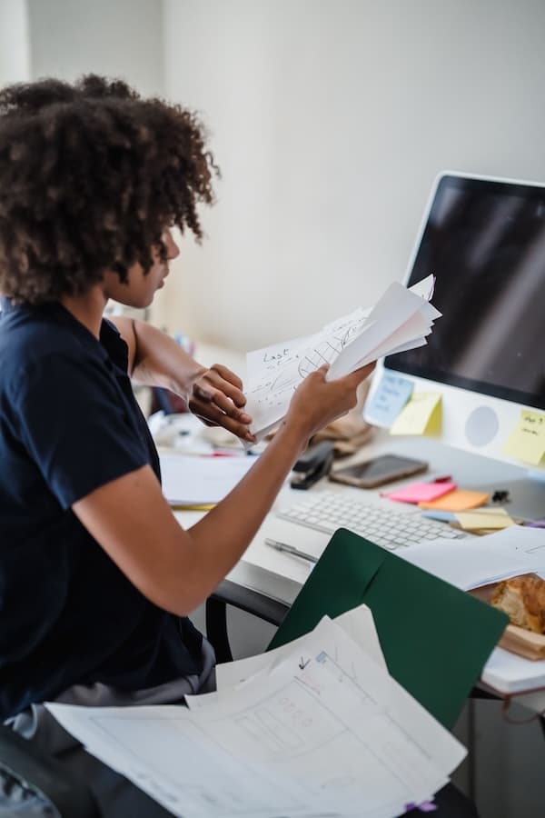 Adolescent organisant des documents devant un écran