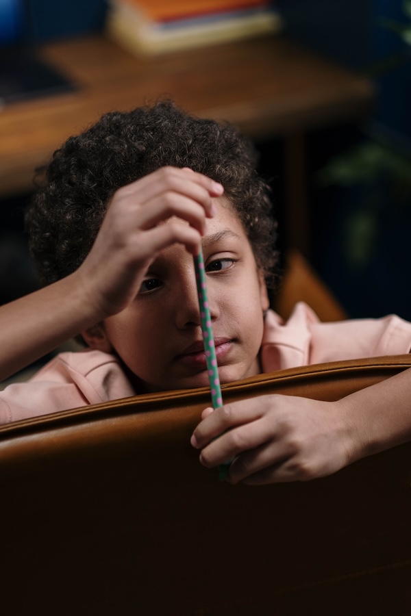 Enfant observant un crayon pendant une activité scolaire