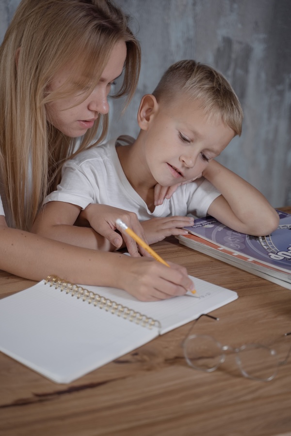 Parent accompagnant son enfant dans une activité écrite