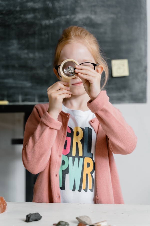 Enfant observant un objet avec une loupe